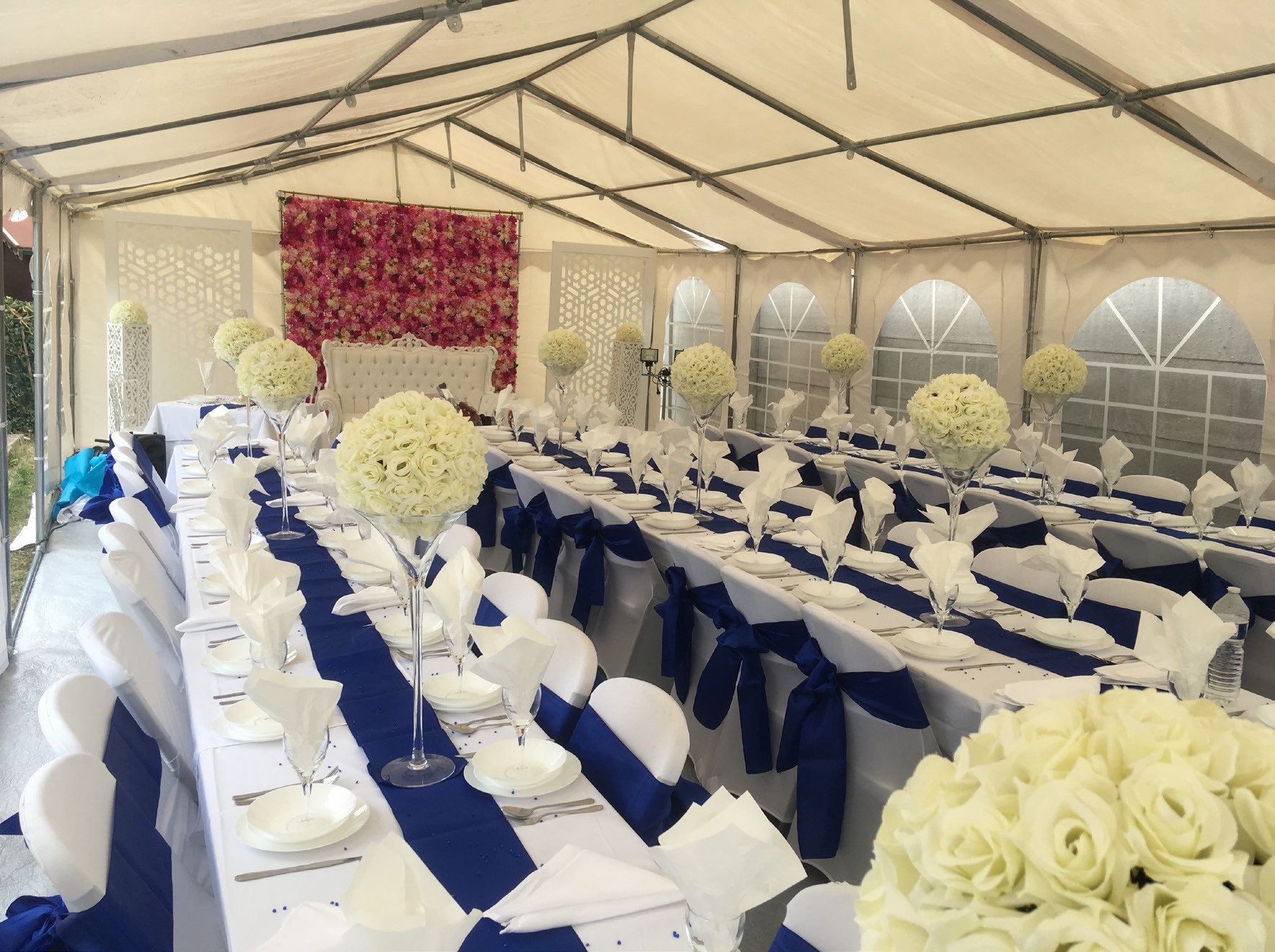 Tables de réception dressées sous une structure blanche, photographie présente dans la plaquette Home Event